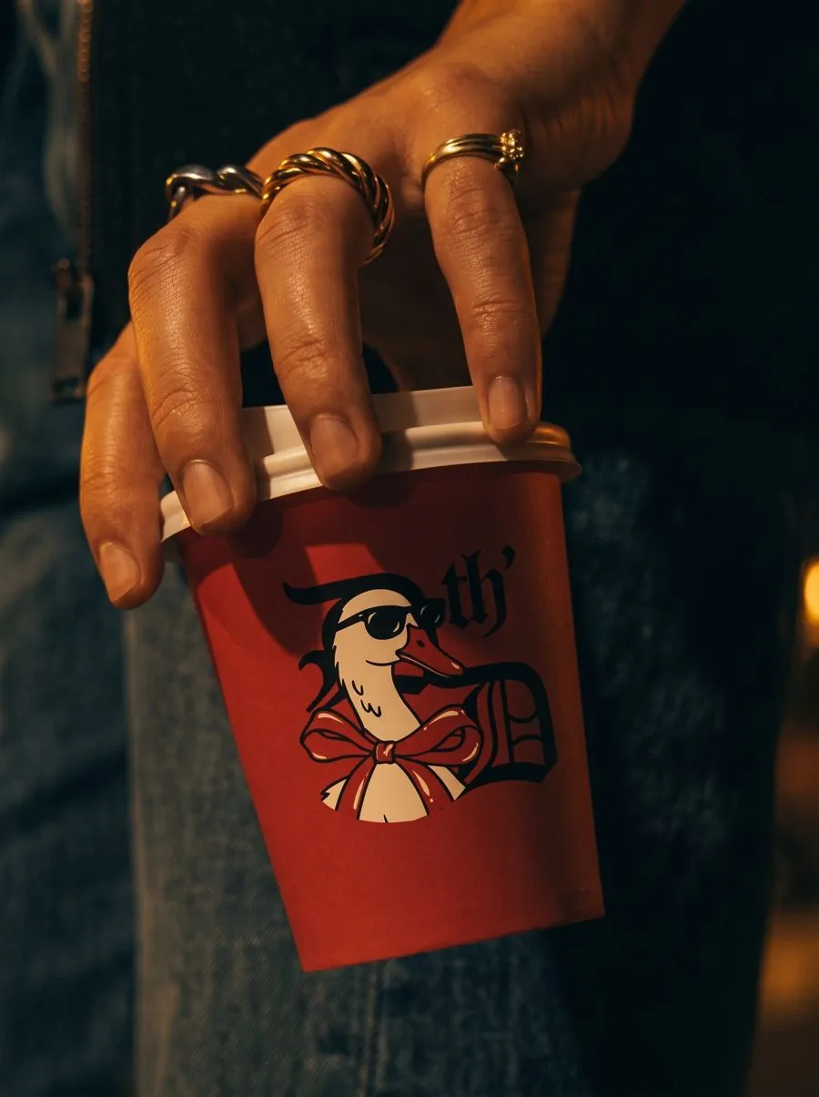 hand holding a Drink th' Drink cup